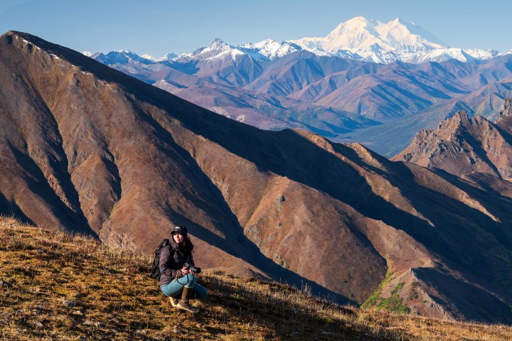 A photographer with mountain range in the background.