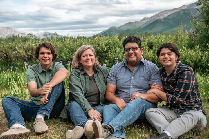 a group of people sitting on a bench posing for the camera