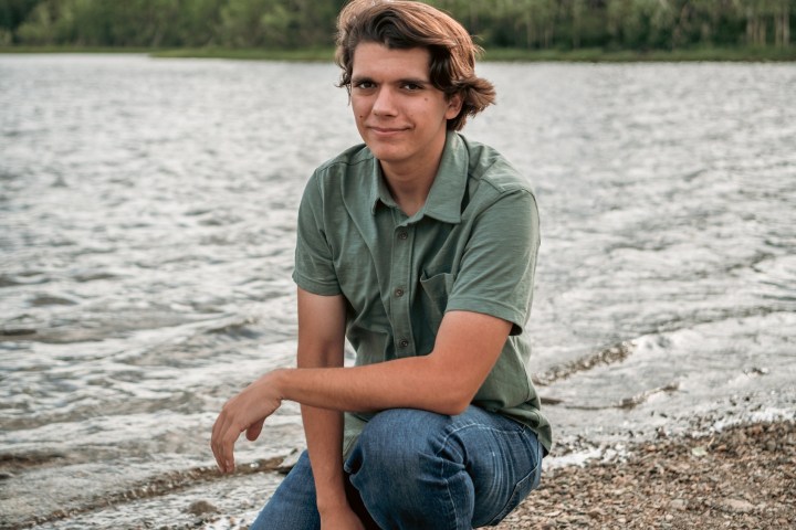 a man standing next to a body of water