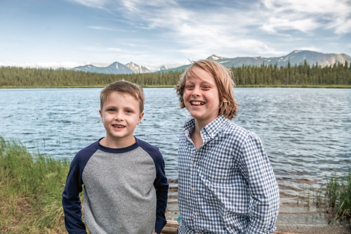 a man standing next to a body of water posing for the camera